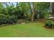 Expansive backyard with a stone fire pit, surrounded by lush greenery and a well-maintained lawn at 1518 Cambridge Ave, Atlanta, GA 30337