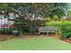 Secluded backyard nook with wooden bench seat surrounded by lush plantings at 1518 Cambridge Ave, Atlanta, GA 30337