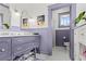 Stylish bathroom with purple vanity, decorative mirrors, and black and white patterned tile floors at 1518 Cambridge Ave, Atlanta, GA 30337