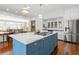 Open kitchen design with a blue island, marble countertops, stainless appliances, and hardwood floors at 1518 Cambridge Ave, Atlanta, GA 30337