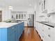 Well-lit kitchen features a blue island with marble counters and modern stainless-steel appliances at 1518 Cambridge Ave, Atlanta, GA 30337