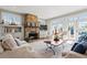 Bright living room featuring a stone fireplace, two sofas, chairs, and many windows offering ample natural light at 1518 Cambridge Ave, Atlanta, GA 30337
