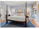Comfortable main bedroom with a four-poster bed, lots of natural light, hardwood floors, and built-in shelves at 1518 Cambridge Ave, Atlanta, GA 30337