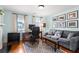 Comfortable home office with a gray sofa, wood floors, and plenty of natural light at 1518 Cambridge Ave, Atlanta, GA 30337