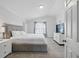 A modern bedroom with a gray upholstered bed, TV, and plenty of natural light at 2304 Stancrest Ln, Lawrenceville, GA 30044