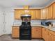 Open kitchen with granite countertops and wood cabinets showcases modern black appliances at 2304 Stancrest Ln, Lawrenceville, GA 30044