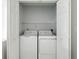 A laundry closet with open double doors, showcasing a side-by-side washer and dryer at 2304 Stancrest Ln, Lawrenceville, GA 30044