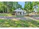 This exterior shot showcases a white detached garage or carport featuring white pillars and a verdant lawn at 4285 Hurt Bridge Rd, Cumming, GA 30028