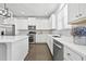 Well-lit modern kitchen with stainless steel appliances, white cabinetry, quartz countertops, and a large island at 4362 White Spruce Aly, Doraville, GA 30360