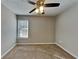 Carpeted bedroom with ceiling fan, window, and neutral colored walls at 930 Rafington Dr, Lawrenceville, GA 30046