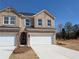 Newly constructed two-story townhome with brick facade, gray shutters and a two car garage at 960 Elwood St, Dacula, GA 30019