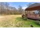 Large grassy yard with a wood deck, gazebo and wooded backdrop at 1710 Meadowchase Ct, Snellville, GA 30078