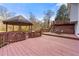 Large backyard with a spacious wood deck featuring a gazebo and stairs leading to the lawn at 1710 Meadowchase Ct, Snellville, GA 30078