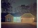 Night view featuring a charming home with stone accents, light green siding, and a welcoming front entrance at 6022 Fieldcrest Dr, Morrow, GA 30260