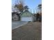 Home featuring a two-car garage with a stone facade, complemented by light green siding and a newly seeded lawn at 6022 Fieldcrest Dr, Morrow, GA 30260