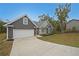 Exterior shot featuring a driveway, garage, and home with pleasant landscaping against a clear blue sky at 92 Fairview Oak Trce, Dallas, GA 30157