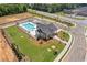 Aerial view of community pool and amenities surrounded by manicured landscaping, parking area, and a playground at 956 Elwood St, Dacula, GA 30019