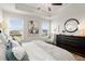 Bedroom featuring a ceiling fan, tray ceiling, two windows and a reading chair at 956 Elwood St, Dacula, GA 30019