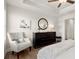 Serene bedroom with elegant furnishings, featuring a padded chair and wooden dresser, all complemented by a ceiling fan at 956 Elwood St, Dacula, GA 30019