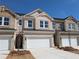 Well-kept townhouse featuring a brick facade, two-car garage, and tidy front yard at 956 Elwood St, Dacula, GA 30019