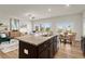 An open floorplan kitchen with stainless steel appliances that flows into a living and dining area at 956 Elwood St, Dacula, GA 30019