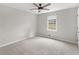 A carpeted bedroom featuring a ceiling fan, a window, and neutral-colored walls at 1605 Mcgarity Rd, Mcdonough, GA 30252