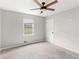 A bedroom with neutral walls, carpeted floors, and a bright window at 1605 Mcgarity Rd, Mcdonough, GA 30252