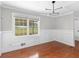 Bright living room showcasing large window, classic wainscoting, and hardwood floors at 1605 Mcgarity Rd, Mcdonough, GA 30252