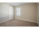 Cozy bedroom with neutral walls, plush carpet, and a window with blinds at 1932 Rosewood Rd, Decatur, GA 30032