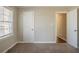 Bedroom featuring neutral walls, carpeted floor, window with blinds, and a door leading to another room at 1932 Rosewood Rd, Decatur, GA 30032