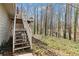 Backyard view of stairs leading up to a deck, surrounded by a scenic wooded area and foliage at 67 Oak Landing Way, Douglasville, GA 30134