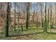 Image of wooded backyard featuring natural areas and home in the distance at 67 Oak Landing Way, Douglasville, GA 30134