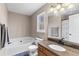 Bathroom featuring bath tub, granite topped vanity, updated fixtures, and lots of natural light at 67 Oak Landing Way, Douglasville, GA 30134