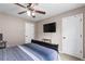 Neutral bedroom featuring a ceiling fan, TV, and large bed with striped bedding at 67 Oak Landing Way, Douglasville, GA 30134