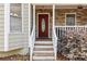 Inviting front entrance with a decorative wood door, stone accents, and painted wood trim at 67 Oak Landing Way, Douglasville, GA 30134