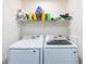 Bright laundry room features front load washer, front load dryer, and upper shelf storage at 975 Fox Valley Trl, Stone Mountain, GA 30088