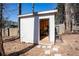 A modern outdoor shed with an open door and a concrete path leading to the entrance at 975 Fox Valley Trl, Stone Mountain, GA 30088