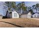 Side view of home showcasing the white brick and siding, gray roof, and dormant lawn leading up to the house at 975 Fox Valley Trl, Stone Mountain, GA 30088