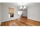 Dining room features hardwood floors, a chandelier, and large windows with a woven shade at 110 Great Oaks Ln, Roswell, GA 30075