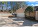 Two car garage with a newly sealed driveway in front of a traditional style, two story home at 110 Great Oaks Ln, Roswell, GA 30075