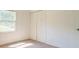 Bedroom with neutral carpet, window, and closet with bi-fold doors at 2811 Bay Leaf Se Dr, Conyers, GA 30094