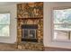 Living room featuring stone fireplace, two windows, and neutral carpet flooring at 2811 Bay Leaf Se Dr, Conyers, GA 30094