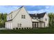 Side view of a home with white siding, a three car garage, and a covered porch area at 6206 Cedarcrest Nw Rd, Acworth, GA 30101