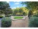 Lush backyard featuring manicured lawn, mature trees, and gravel path at 700 Park Regency Ne Pl # 603, Atlanta, GA 30326