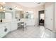 Bright main bathroom with dual sinks, vanity area, white cabinetry and tile flooring at 3735 Holiday Lane Ln, Atlanta, GA 30349