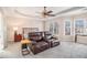 Spacious main bedroom boasts a tray ceiling, ceiling fan, and a comfortable sitting area with a recliner at 3735 Holiday Lane Ln, Atlanta, GA 30349