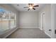 Bright bedroom with neutral carpet, a ceiling fan, a large window and a side door at 1502 Park Hollow Ln, Lawrenceville, GA 30043