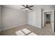 A large bedroom with a ceiling fan, carpet floors, neutral-colored walls, and natural light from the window at 1502 Park Hollow Ln, Lawrenceville, GA 30043