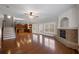 Bright living room featuring a brick fireplace, hardwood floors, and seamless flow into the open-plan kitchen at 1502 Park Hollow Ln, Lawrenceville, GA 30043