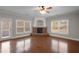 Cozy living room showcasing a brick fireplace, gleaming hardwood floors, and large windows for ample natural light at 1502 Park Hollow Ln, Lawrenceville, GA 30043